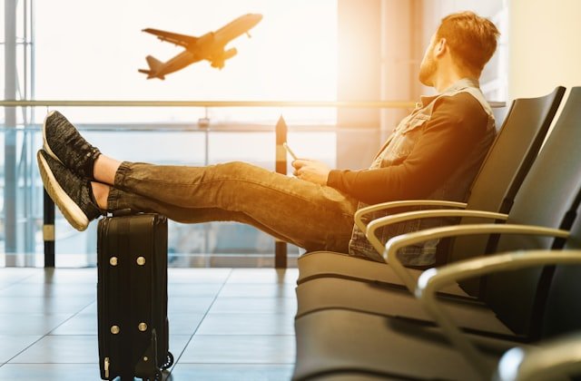 Relaxed traveller waiting at the airport as a plane takes off